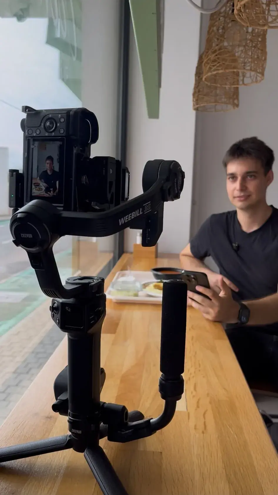 Pregătirea unei filmări: telefon montat pe gimbal, pe o masă de lucru